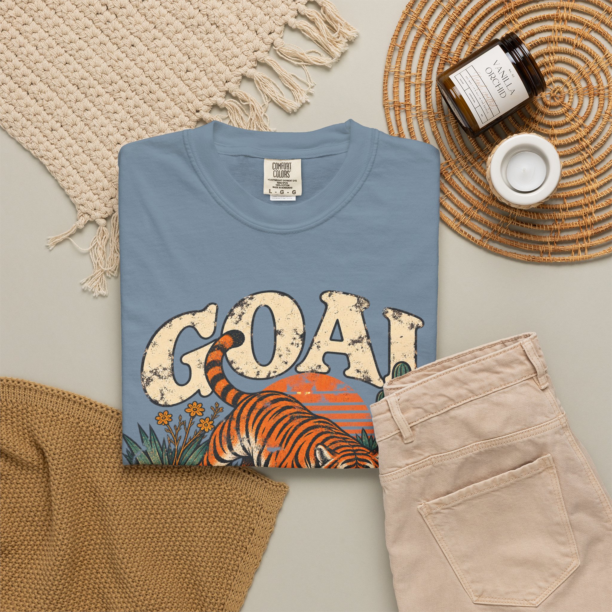 Blue Goal Digger T-shirt, folded with the front design visible beside beige trousers.